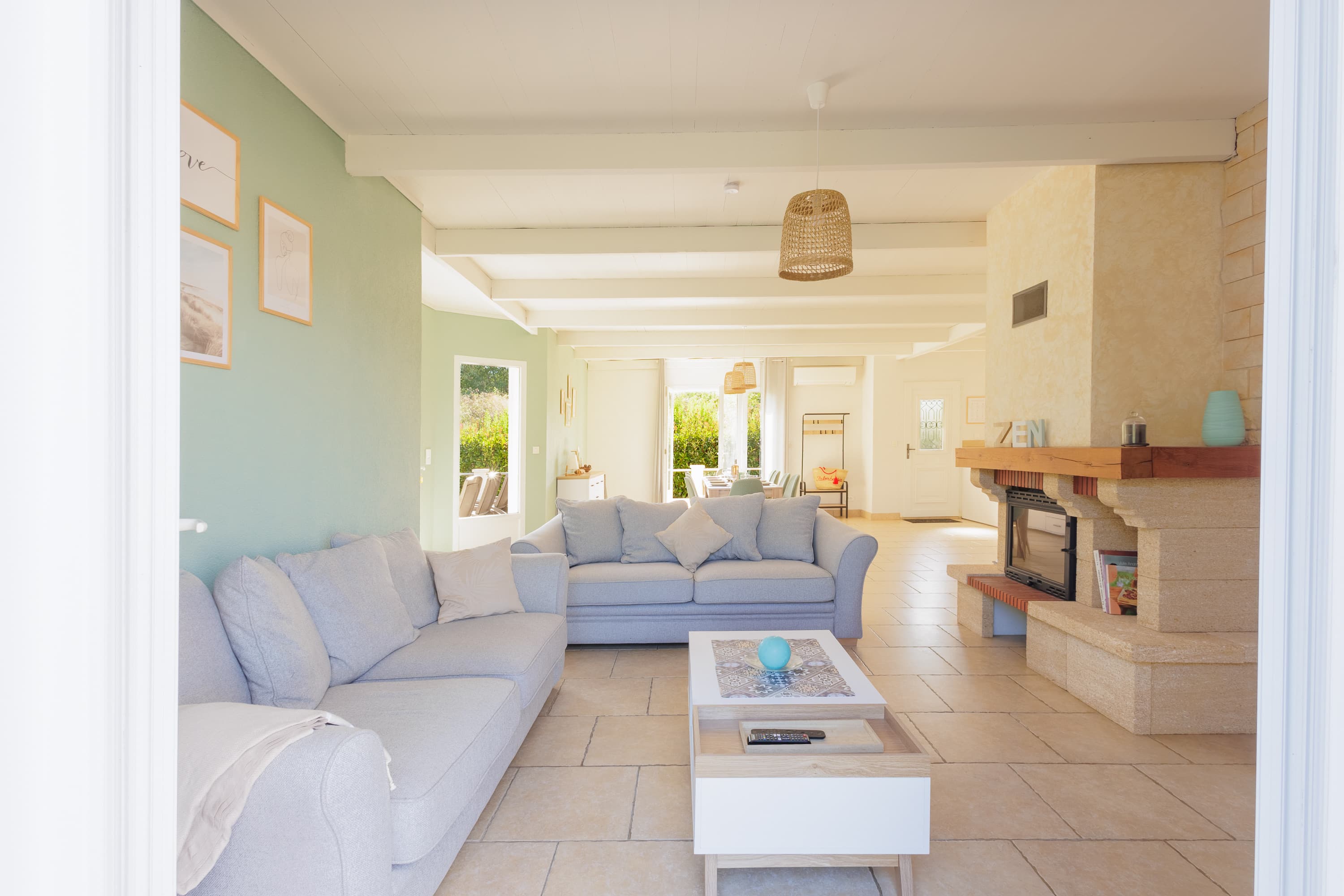 Séjour ouvert et lumineux de la villa avec canapés et cheminée