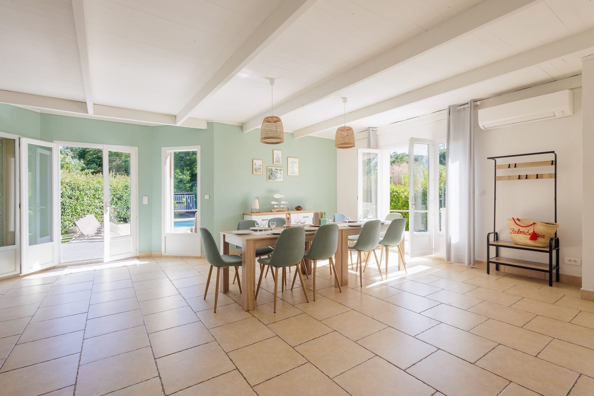 Grande salle à manger lumineuse ouverte sur le jardin et la piscine