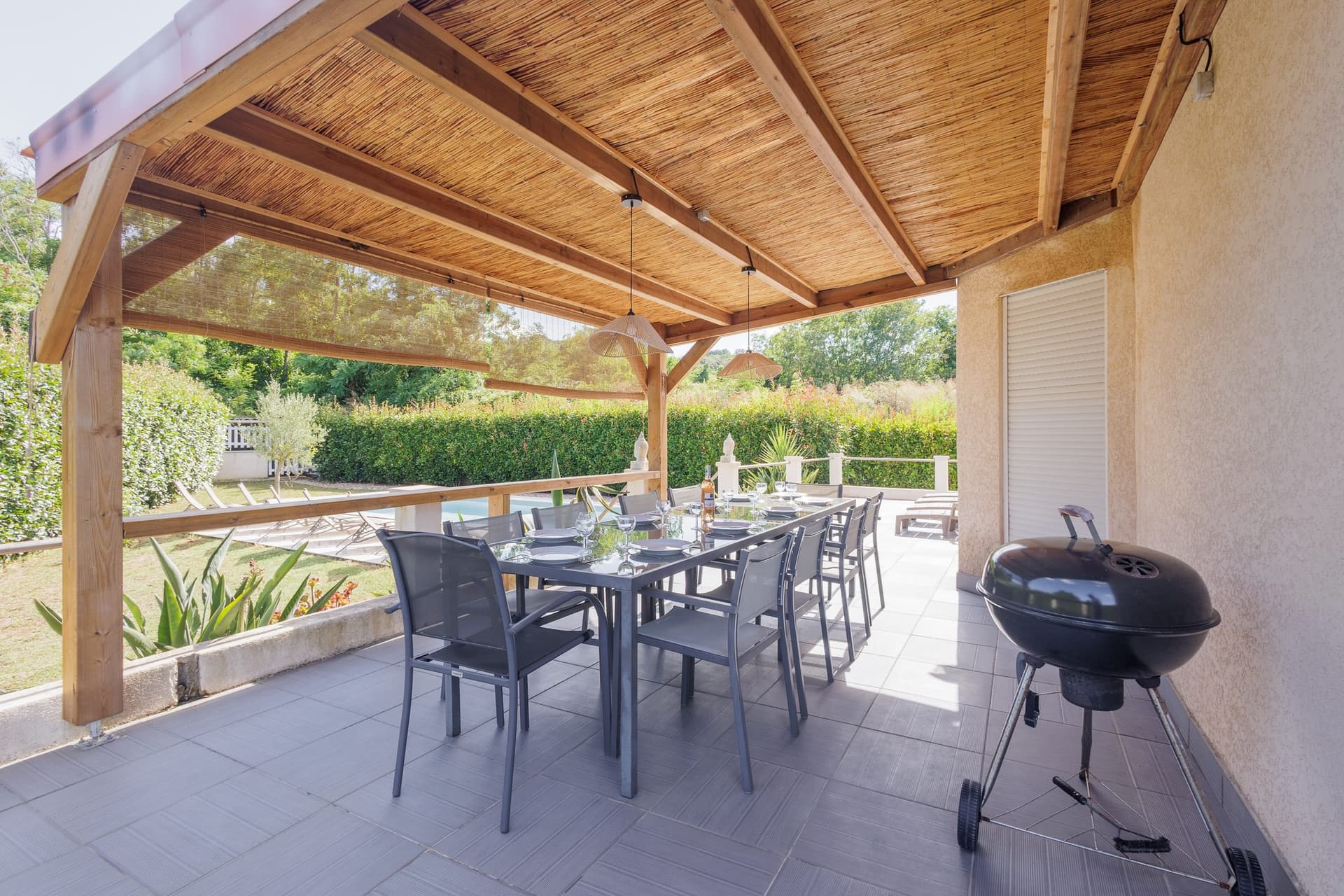 Terrasse couverte sous pergola avec table pour 10 et barbecue
